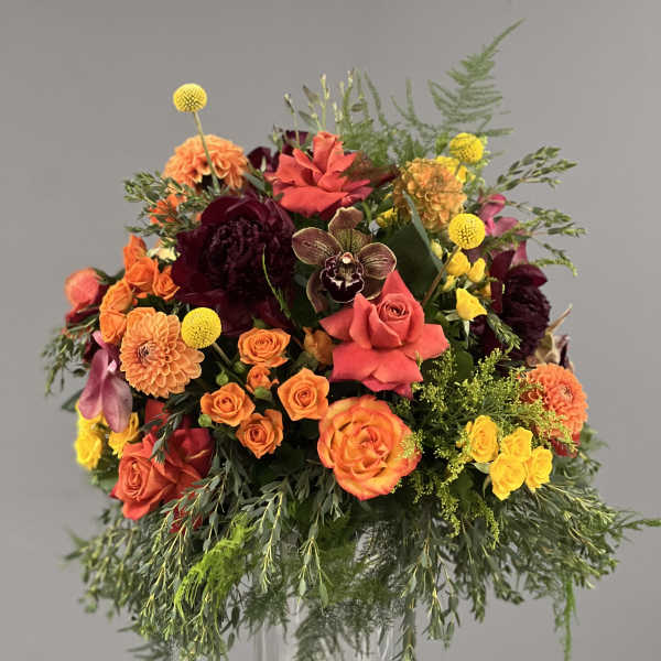 Mixed orange, pink, and yellow bouquet in a clear glass vase