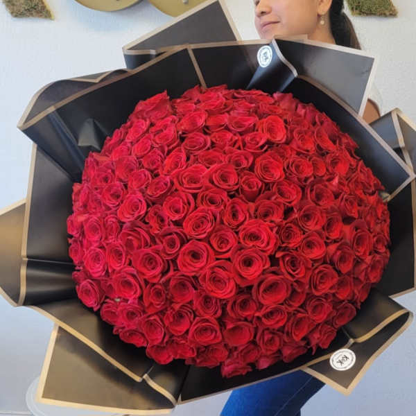 Large bouquet of red roses wrapped in black paper