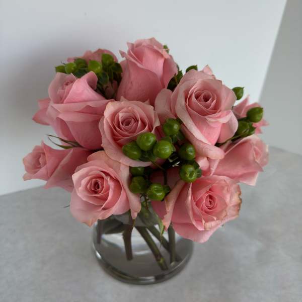 Pink roses arranged in a clear glass vase