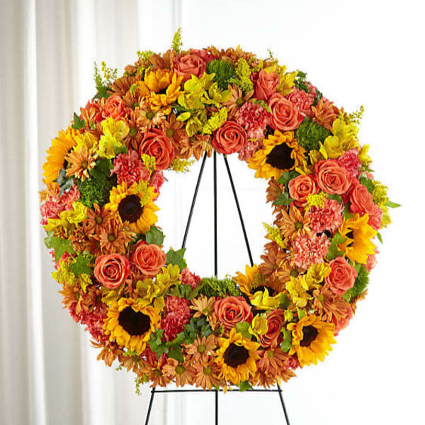 Autumn floral wreath on a black easel with sunflowers and roses
