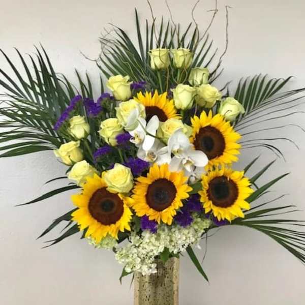 Sunflower and pale yellow rose arrangement in a tall vase