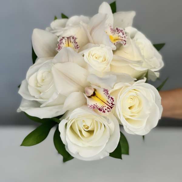 White rose and orchid bouquet with green leaves