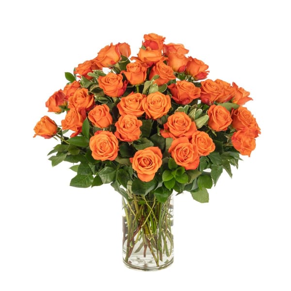 Large bouquet of bright orange roses arranged in a clear glass cylinder vase