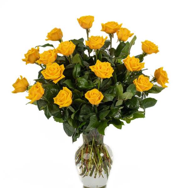 Tall arrangement of yellow roses in a clear glass vase