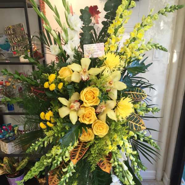 Tall yellow floral standing spray with roses and orchids