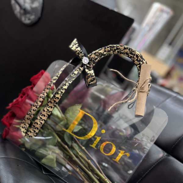 Bouquet of red roses in a clear gift bag with a decorative handle