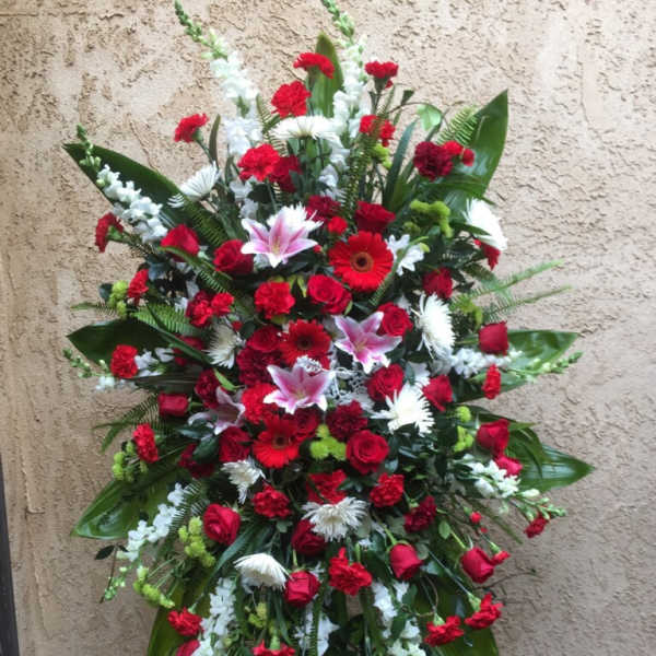 Large standing floral spray with red, white, and pink blooms