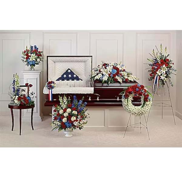 Sympathy floral set with red, white, and blue arrangements around a casket