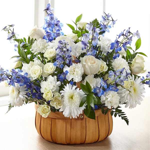 White and blue floral arrangement in a wooden basket