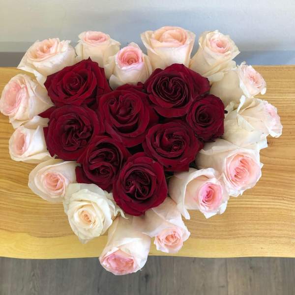 Heart-shaped bouquet of red and pale pink roses