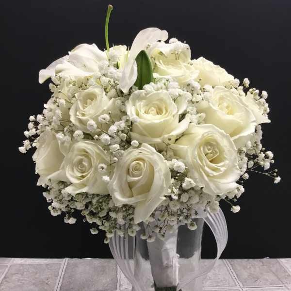 White rose bouquet with baby’s breath in a clear glass vase