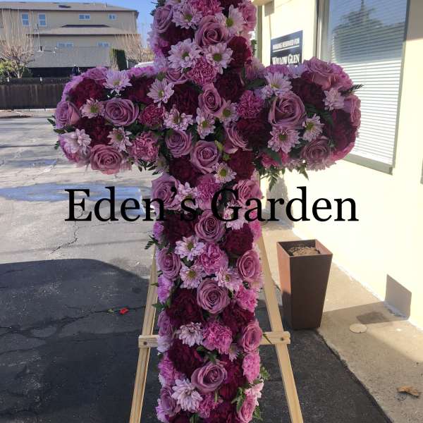 Pink and purple floral cross on a wooden easel