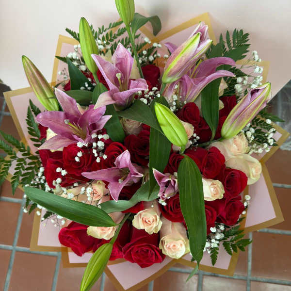 Bouquet of red and cream roses with pink lilies