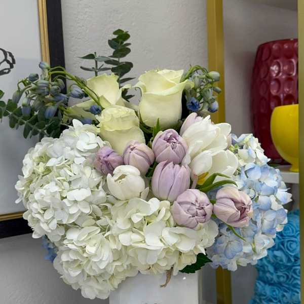 White and pastel flower arrangement in a white vase