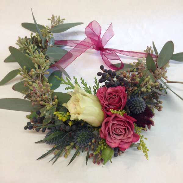 Heart-shaped floral wreath with pink roses and a ribbon bow