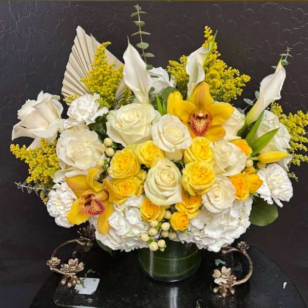 Yellow and white floral arrangement in a glass vase