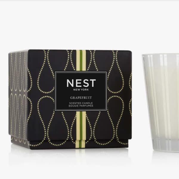 Scented candle in a frosted glass tumbler beside its black box