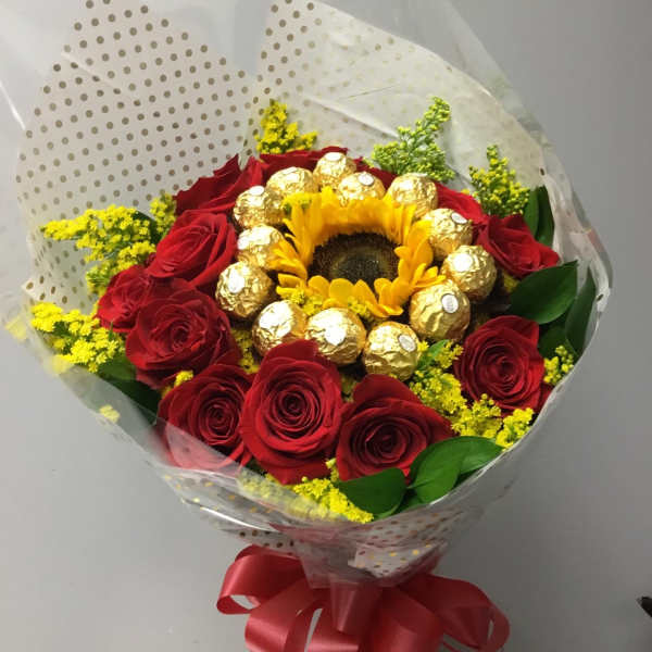 Bouquet of red roses with a sunflower center and gold-wrapped chocolates