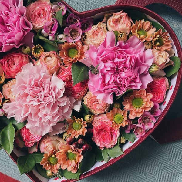 Heart-shaped box of pink and peach flowers