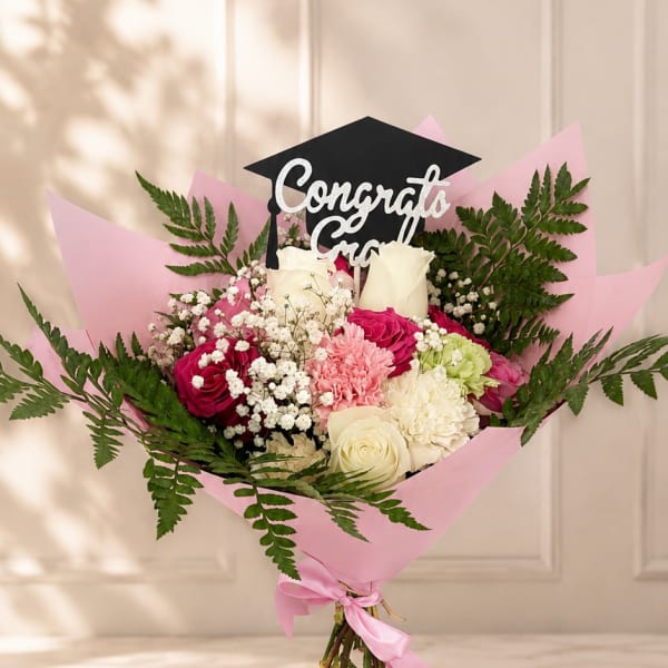 Pink and white bouquet with a graduation topper and ribbon