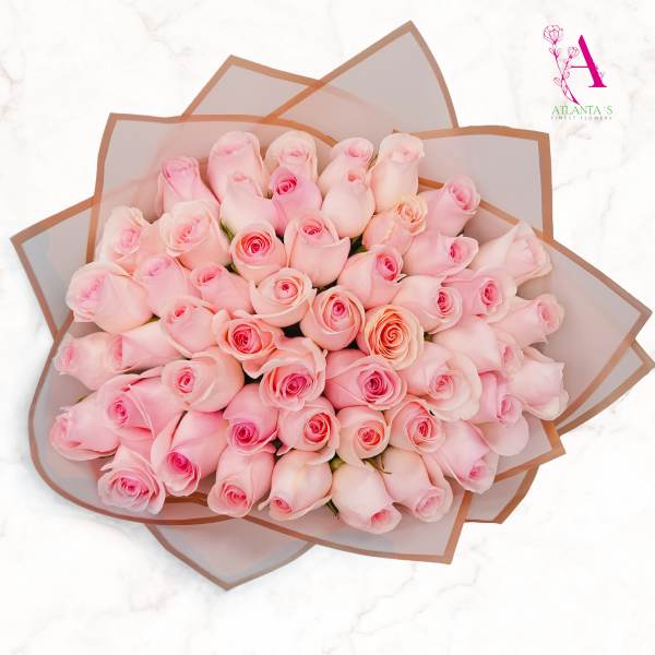 Large bouquet of pale pink roses wrapped in translucent paper