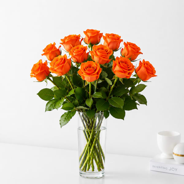 Orange roses arranged in a clear glass vase