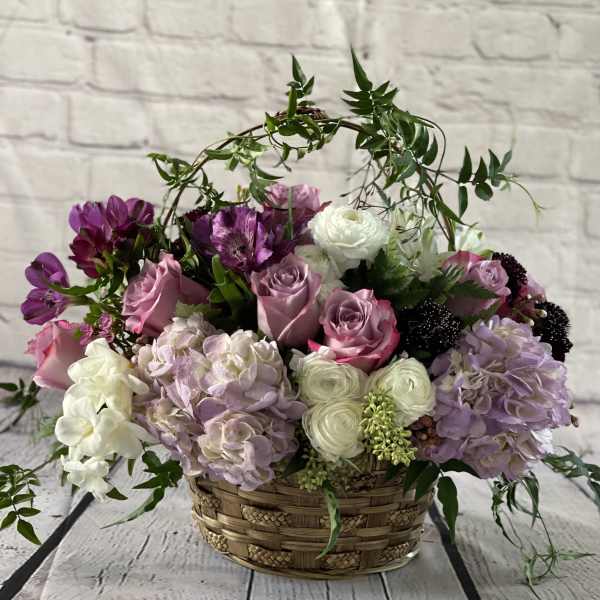 Basket arrangement of pink, white, and purple flowers