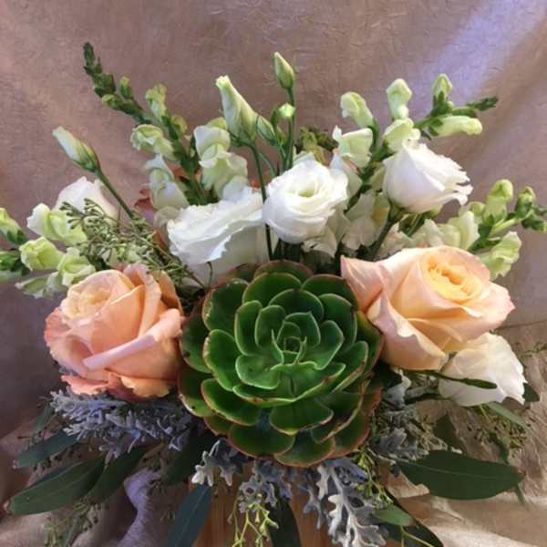 Peach and white roses with snapdragons and a green succulent in a wooden container