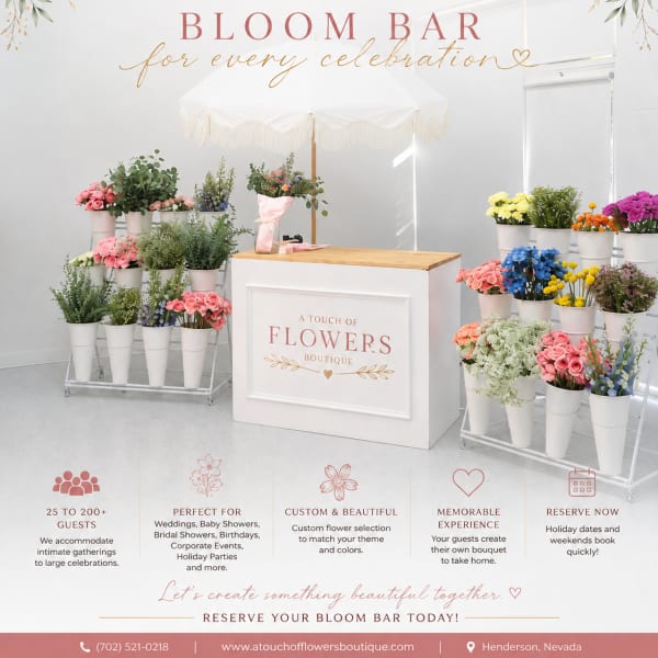 Bloom bar display with assorted flowers in white buckets under a canopy