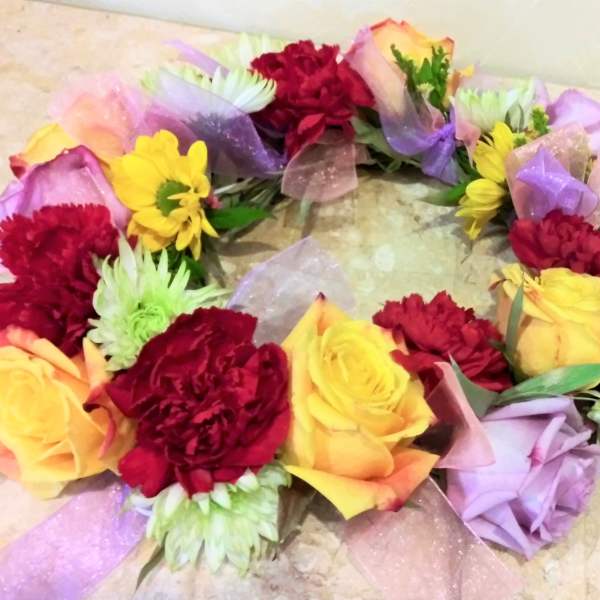 Colorful floral wreath with roses and carnations on a light surface
