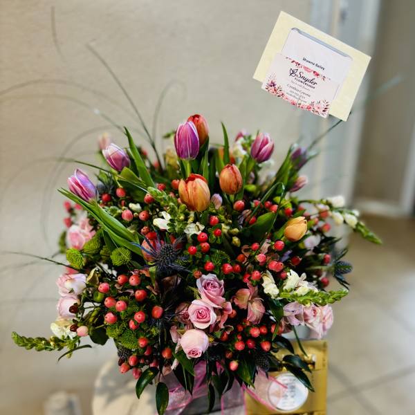 Mixed bouquet with pink roses, tulips, and berries in a gift box
