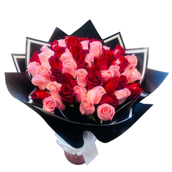 Bouquet of pink and red roses wrapped in black paper