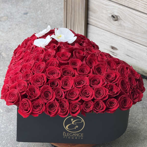 Heart-shaped box of red roses with white orchids on top