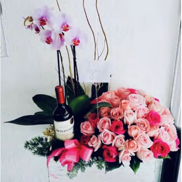 Pink rose bouquet with an orchid stem and a wine bottle in a gift box