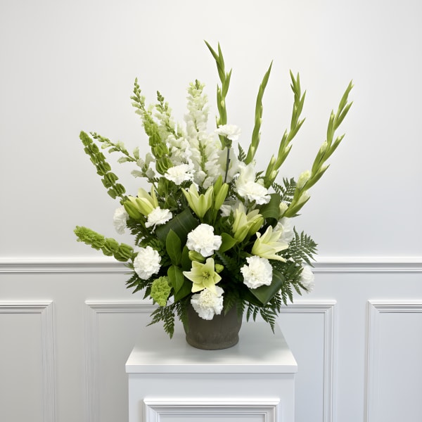 White and green floral arrangement in a dark vase