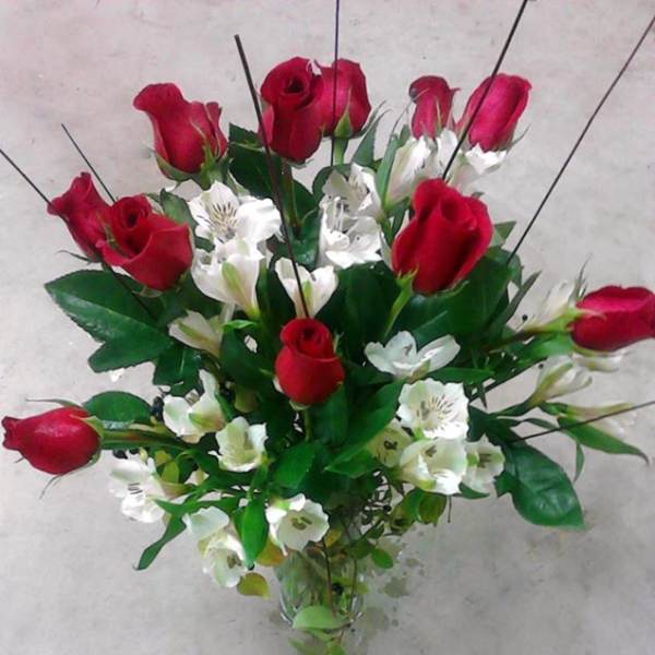Bouquet of red roses and white alstroemeria in a clear glass vase