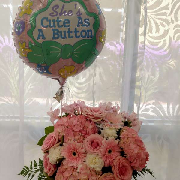 Pink flower bouquet with a "She's Cute As A Button" balloon