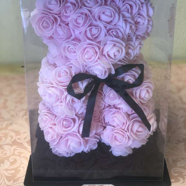 Pink rose-shaped arrangement in a clear display box with a black ribbon
