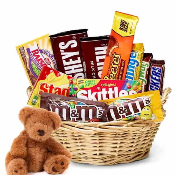 Basket of assorted candy bars with a small teddy bear