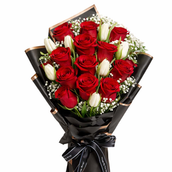 Bouquet of red roses and white tulips wrapped in black paper
