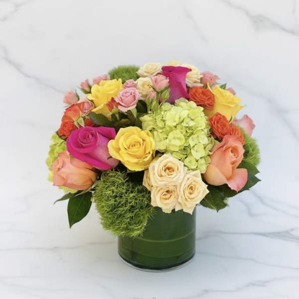 Colorful rose bouquet in a green glass vase