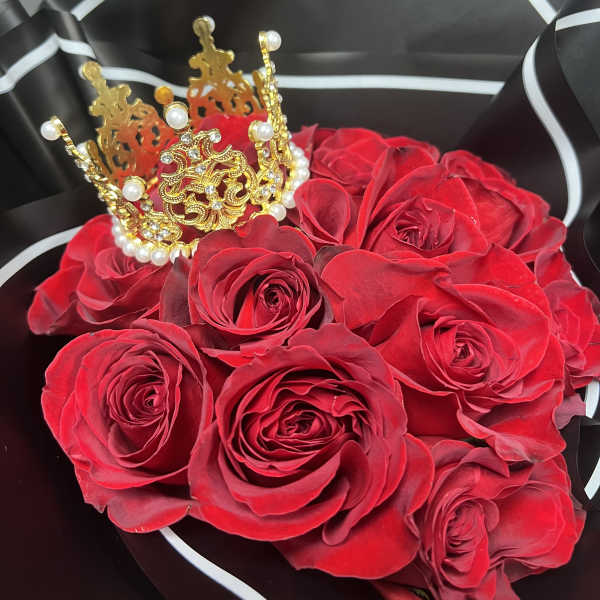 Red roses with a gold jeweled crown in black wrapping