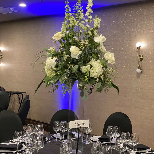 Tall white floral centerpiece on a banquet table