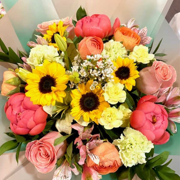 Mixed bouquet with sunflowers, pink roses, and peach blooms