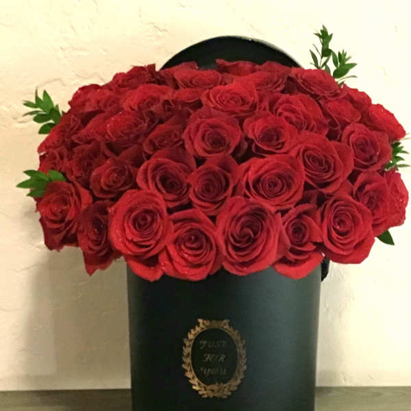Red roses arranged in a black hatbox