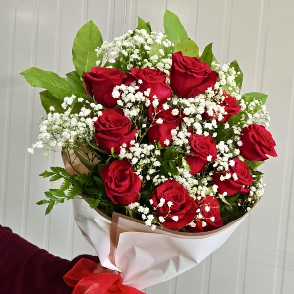 Bouquet of red roses with white baby's breath in white wrapping