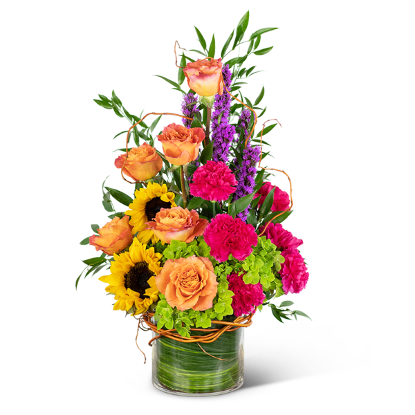 Mixed bouquet with orange roses, sunflowers, pink carnations, and purple spikes in a glass vase
