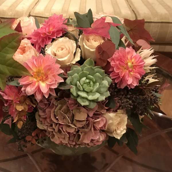 Bouquet of pink and cream flowers with a green succulent in a vase
