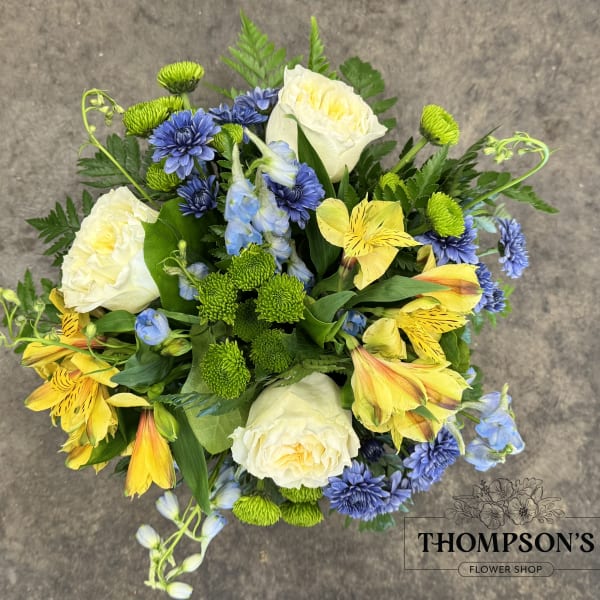 Bouquet of white roses, yellow alstroemeria, and blue flowers