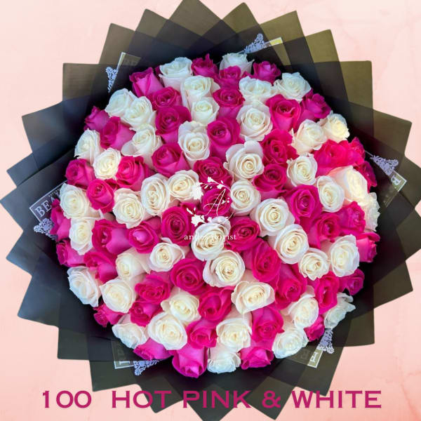 Bouquet of hot pink and white roses wrapped in black paper